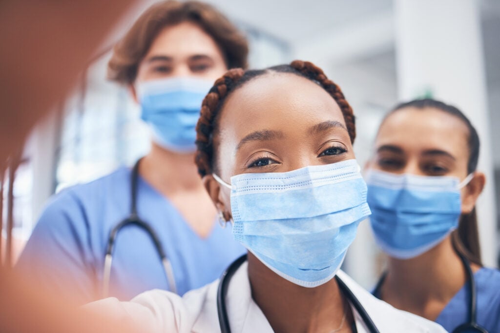 young doctors taking a selfie with PPI masks over their faces