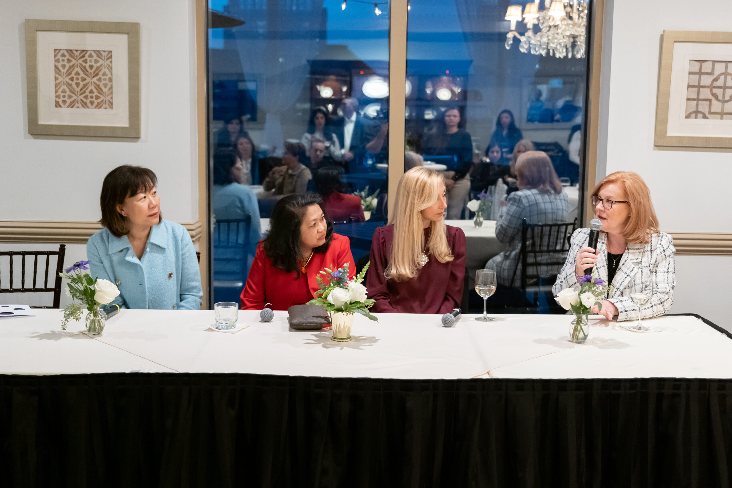 a group of women physicians sitting at a table during a panel discussion