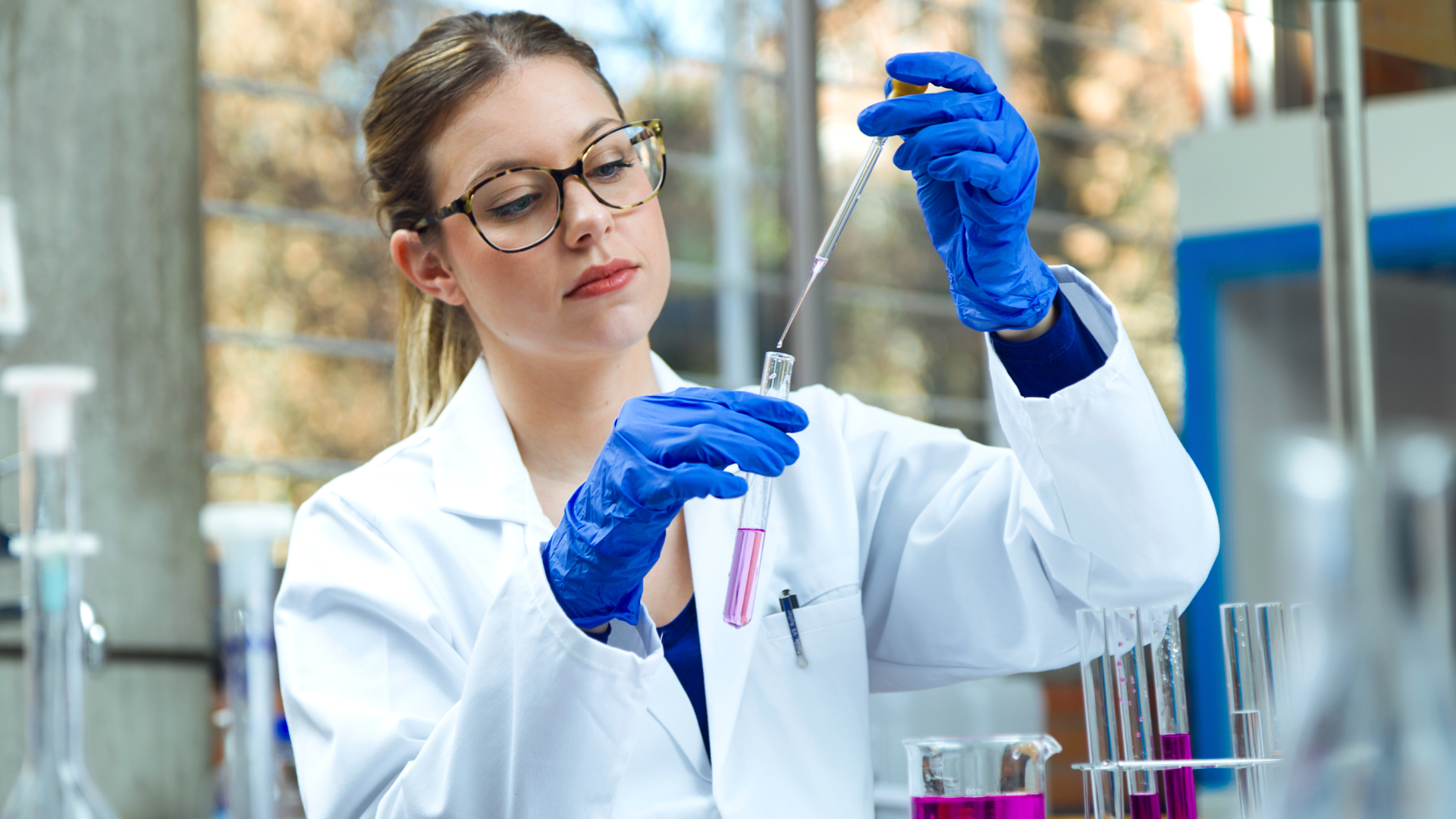 Young woman physician scientist working with test tubes in a laboratory.