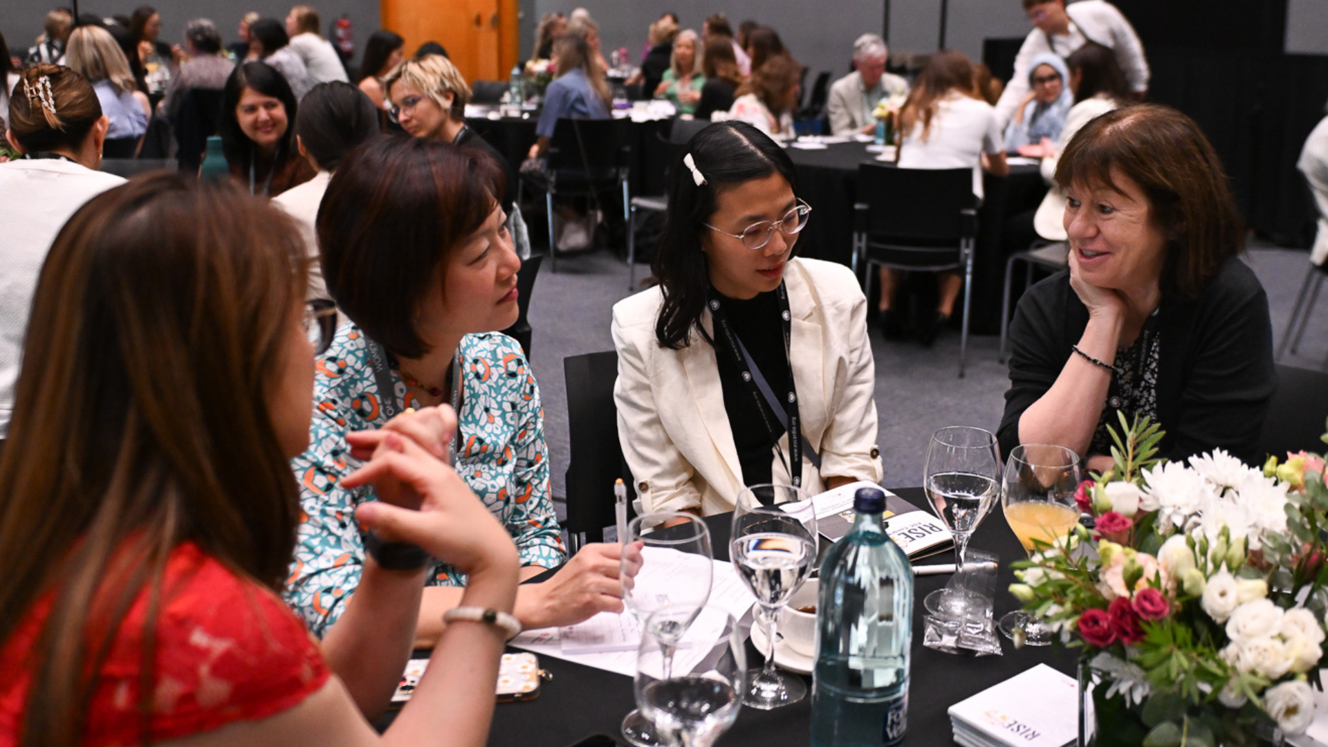 Four women physicians sat at a table having a conversation about global leadership