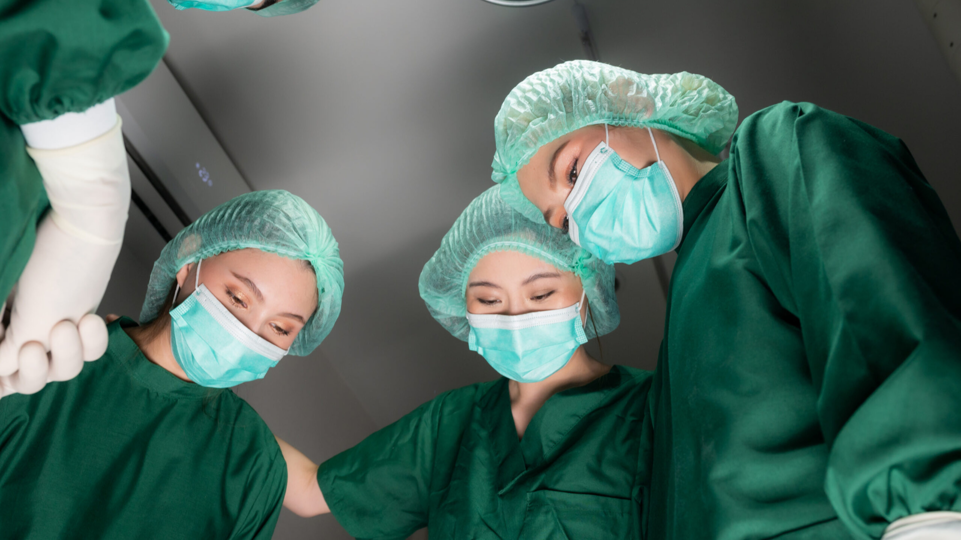 Corporate Membership 8 Three women physicians in scrubs during a procedure